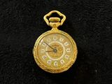 an image of a gold pocket watch with roman numerals on the face