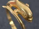un gros plan d'une bague en or ornée d'un poisson