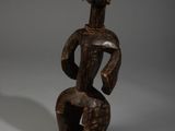 une statue en bois d'un homme avec un chapeau sur la tête