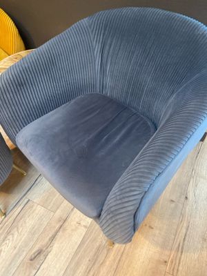 deux chaises bleues dans une pièce avec un parquet et une chaise jaune
