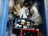 a blue bin filled with assorted items on the floor