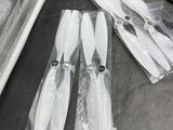 four propellers sitting on the floor next to a remote control