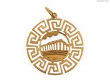 un gros plan d'un pendentif plaqué or orné d'un motif grec