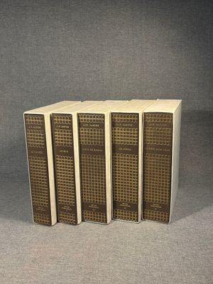 three books are stacked on top of each other on a gray surface