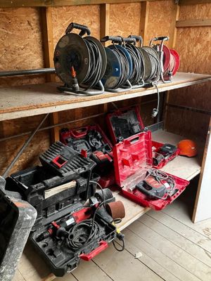 de nombreux outils posés sur une étagère dans un garage