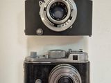 two cameras hanging on the wall next to each other