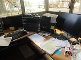 une photo d'un bureau encombré avec deux écrans et un clavier