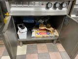 a kitchen with a stove with a bunch of food inside of it