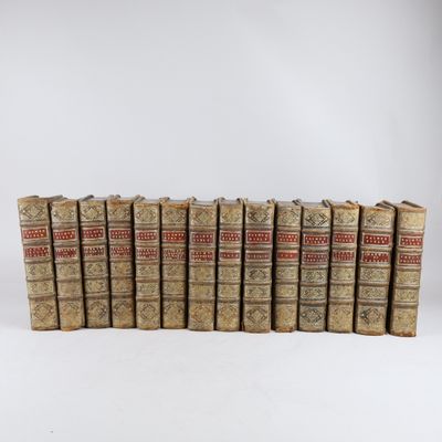 six vieux livres alignés sur une surface blanche