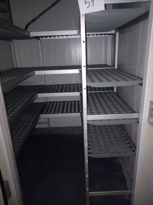 une étagère métallique avec des tablettes, placée au milieu d'une pièce