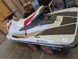 a white and red jet ski on a trailer in a garage