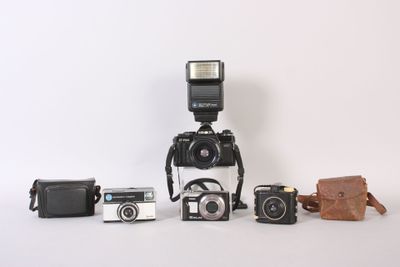 a lot of different types of cameras sitting on a table