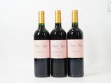 trois bouteilles de vin rouge posées sur une table blanche