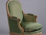 une vieille chaise avec une assise rembourrée verte et des bordures dorées