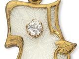 un gros plan d'un pendentif doré et blanc orné d'un diamant