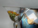 a wine glass sitting on top of a shelf next to a vase