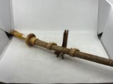 une petite épée en bois dans une boîte posée sur une surface blanche