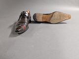 pair of men ' s black leather shoes on a grey surface
