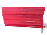several red books stacked on top of each other on a white surface