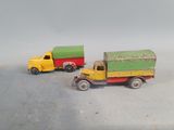 two toy trucks sitting next to each other on a table