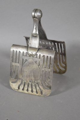 un objet en argent orné d'un oiseau, posé sur une table