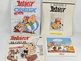 three cartoon books on a table with a notepad and pen