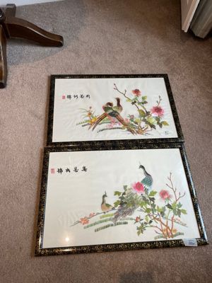 two framed pictures of birds and flowers on the floor