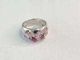 un gros plan d'une bague rose et blanche posée sur une surface blanche