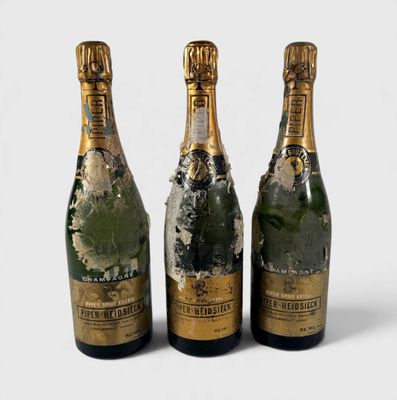 three bottles of champagne sitting next to each other on a white surface