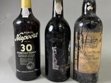 trois bouteilles de vin posées l'une à côté de l'autre sur une table