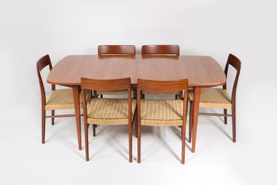 une table entourée de six chaises et une horloge accrochée au mur