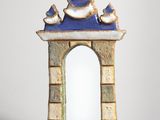 a small blue and white mirror with birds on it
