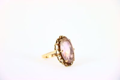 a gold ring with an oval amethorate stone in the center