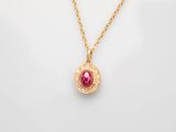 a gold necklace with a ruby stone and diamonds