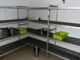 a room with a lot of shelves with pots and pans on them