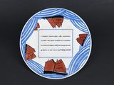une image représentant une assiette bleue et blanche sur laquelle figure l'illustration d'un bateau
