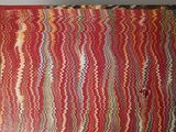 a picture of a red rug with multicolored stripes