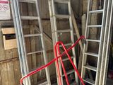 many ladders and a dolly in a garage
