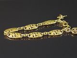 gros plan d'un bracelet en or sur une surface noire