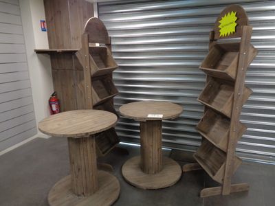 trois tables en bois et une étagère dans une pièce