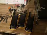 three cell phones sitting on a table next to a bunch of keys