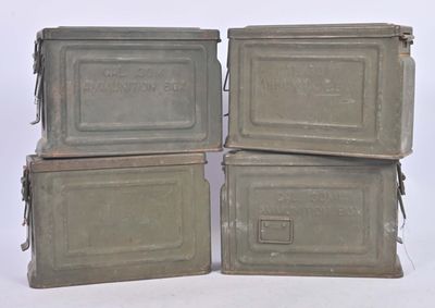 four metal boxes are stacked on top of each other on a white surface