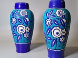 deux vases bleus posés côte à côte sur une surface blanche