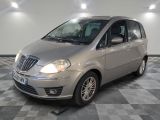 a picture of a small silver car parked in a garage