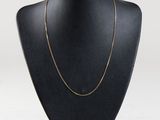 a black mannequin with a gold chain on it