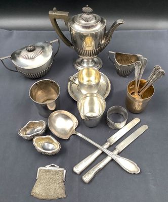 a silver tea set on a table with other silver items