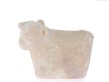 a stone animal that is sitting on a white surface