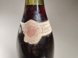 an old bottle of wine sitting on top of a table