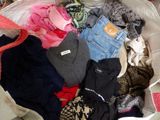 a large bag full of clothes and clothes sitting on a bed
