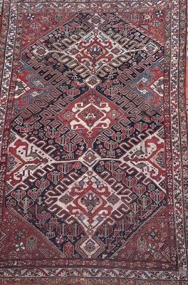 a red and blue rug with a diamond design on it